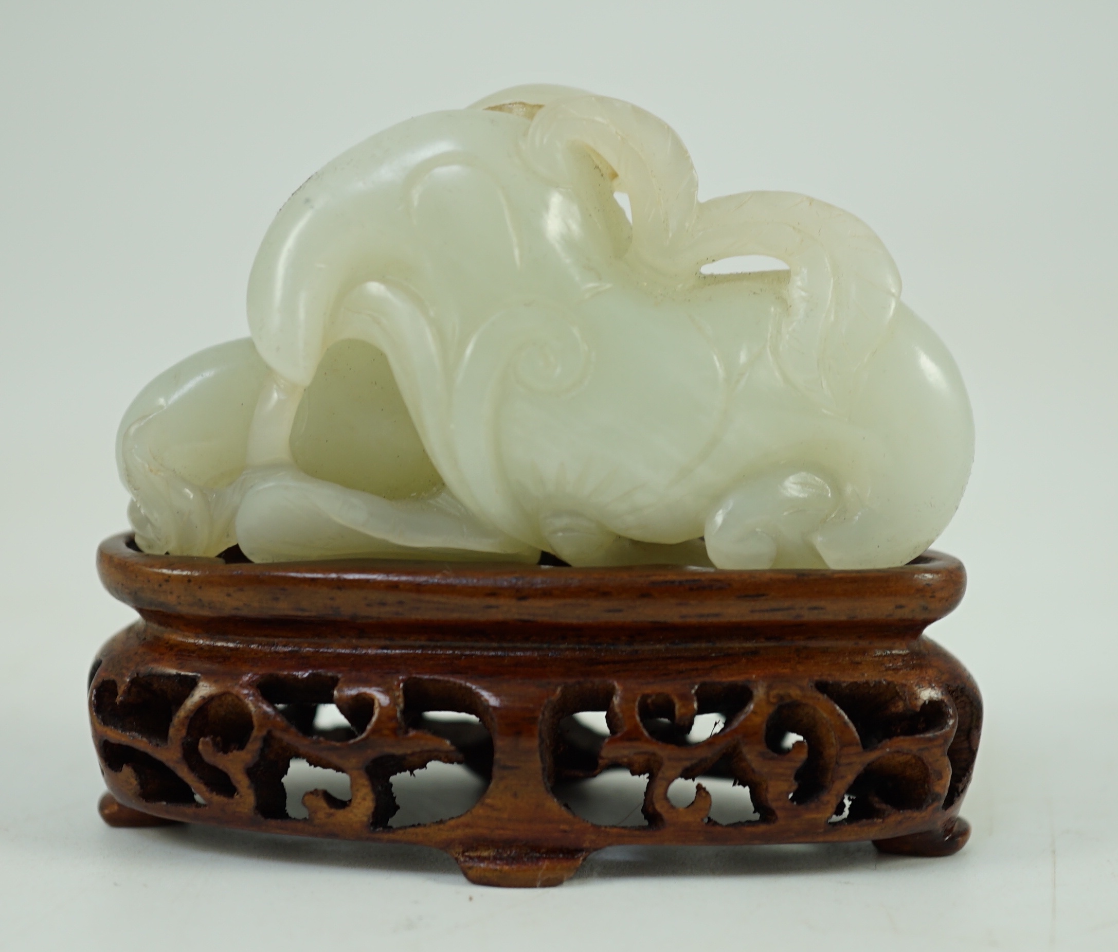 A Chinese pale celadon jade ‘Lotus’ pebble carving, 18th/19th century, 6.2 cm wide, wood stand